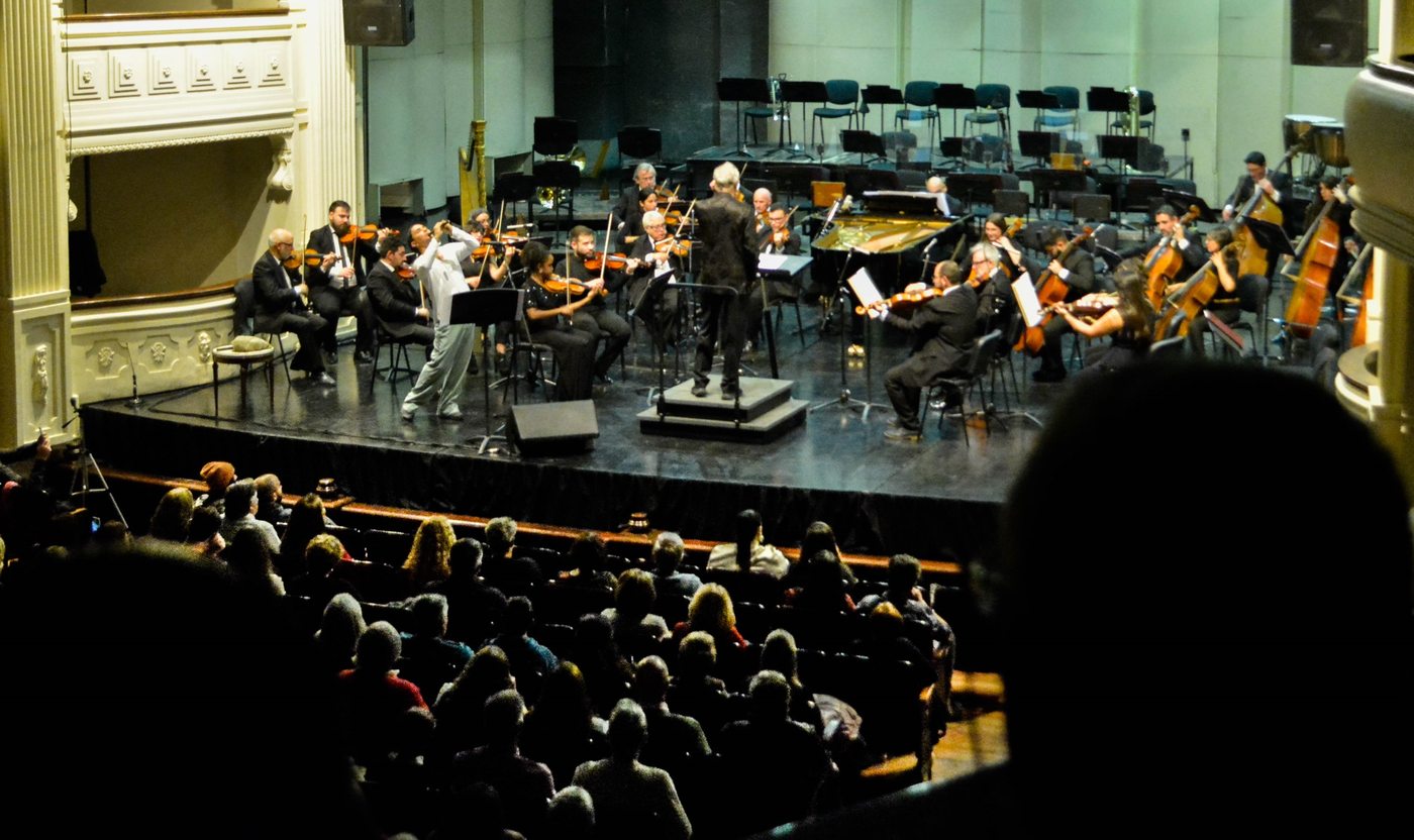 View of the Teatro Independencia hall during the concert: Pablo Salcedo standing, performing the quena with the string orchestra